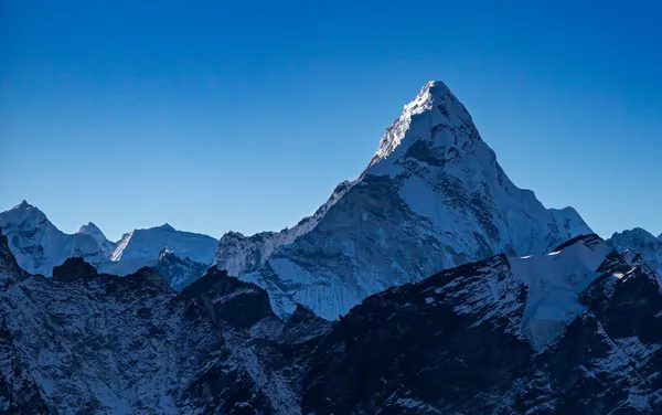 The sharp summit of Ama Dablam glowing under a deep blue sky
