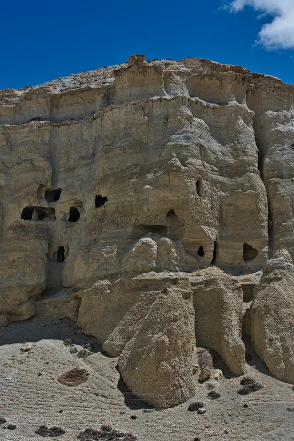 Erosion-carved cliff dwellings lining the canyon walls along the trail to Chosar
