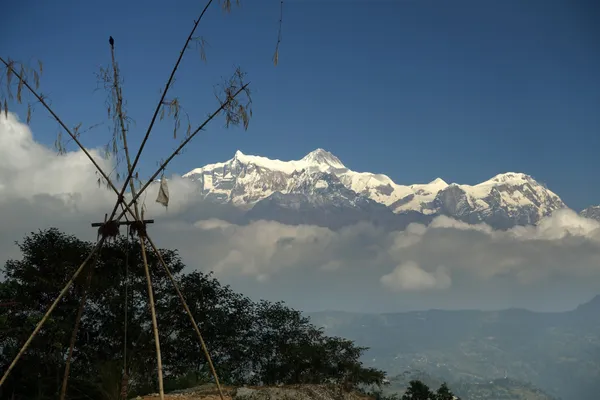 Snow-capped Annapurna peaks piercing through a blanket of morning clouds