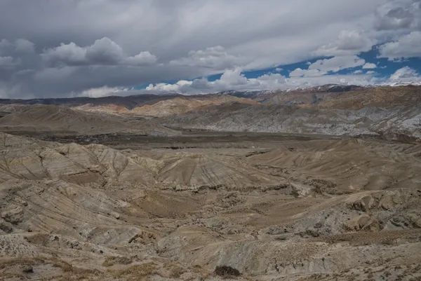 Dramatic wind-sculpted rock formations and deep desert river valleys in Upper Mustang