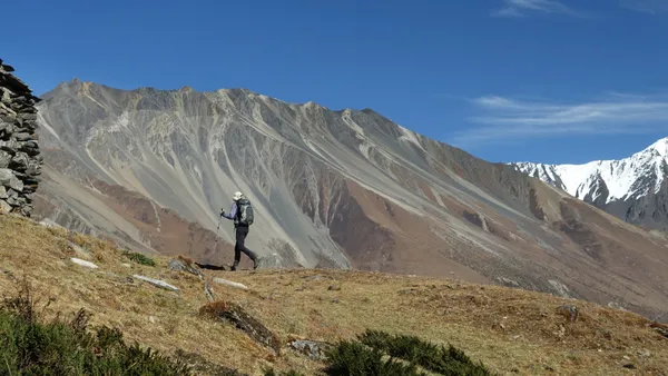A lone trekker ascending a steep mountain path