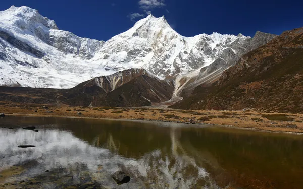 The summit of Mt. Manaslu reflected perfectly in the still waters of glacial Birendra Tal