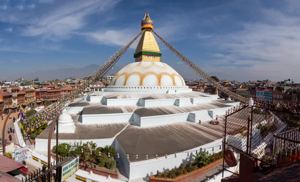 The sacred dome and prayer flags of Boudhanath under a clear blue sky