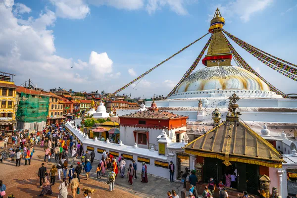 Prayer flags and crowds surrounding the massive white dome of Boudhanath