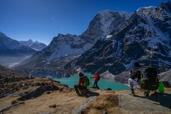 Trekkers photographing Cholatse Lake from a high ridge