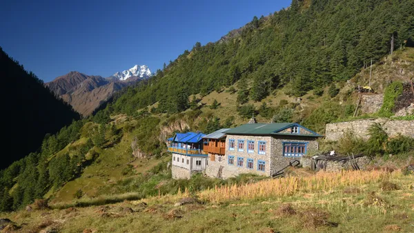 A brightly painted stone house on a grassy hillside