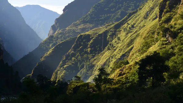 Sunlight illuminating green mountain ridges and valleys