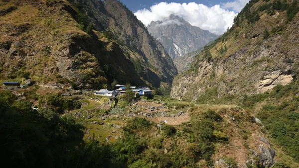 The village of Deng resting on a flat plain encircled by towering mountains