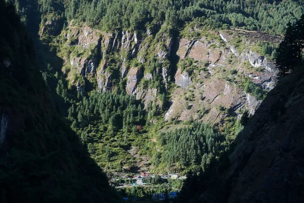 A small village with colorful roofs nestled between deep green mountain slopes