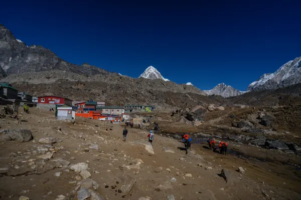Trekkers and porters entering Dzongla beneath Cholatse