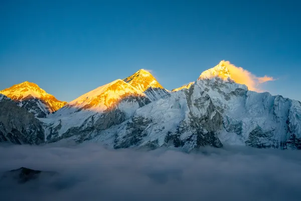 Everest, Nuptse, and Changtse glowing above a cloud inversion at sunset