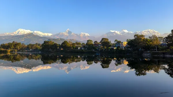 Snow-capped Himalayas mirrored in the still waters of Phewa Lake