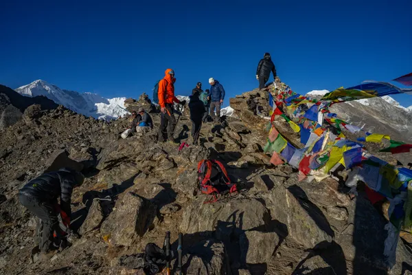 Trekkers reaching the Gokyo Ri summit with Himalayan giants behind