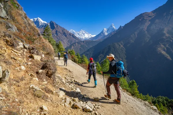 Trekkers on the Everest View trail with Lhotse and Everest behind Ama Dablam