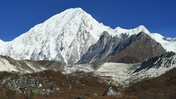 Massive white glaciers and steep rock faces of the high Himalayas