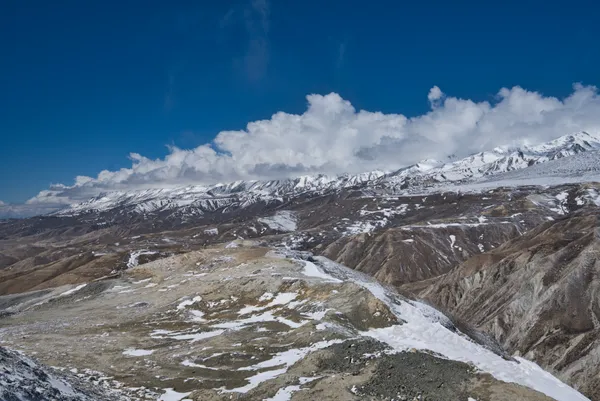 Snow-dusted terrain overlooking the arid valleys of Upper Mustang near a 3,900 m pass
