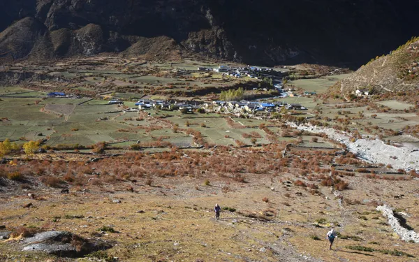 A stone-walled settlement among green fields in the upper valley