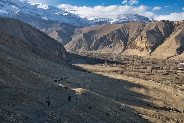 Trekkers descending toward the historic Ghar Gompa monastery at 3,950 m in a lush mountain oasis