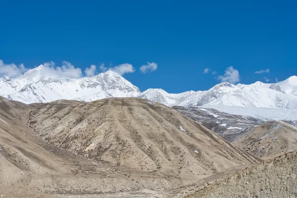 Snow-capped mountain ranges towering over the arid high-altitude desert landscape of Tangya at 3,240 m