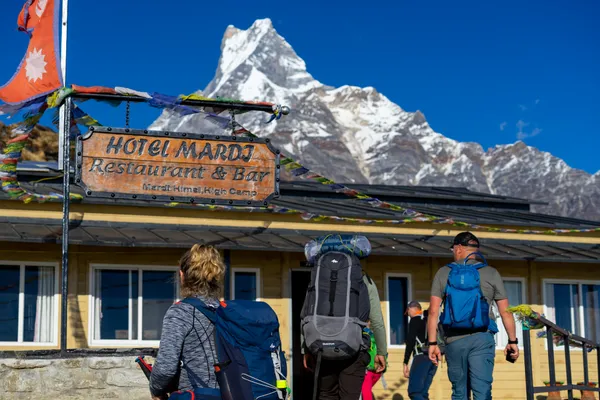 Trekkers arriving at Hotel Mardi in High Camp with Machhapuchhre towering behind