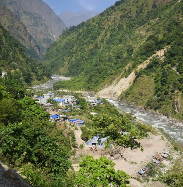 Small houses of Machhakhola Village clustered along the riverbank
