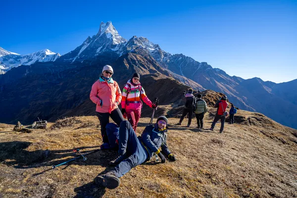 Trekkers resting on a broad ridge with Machhapuchhre towering in the background