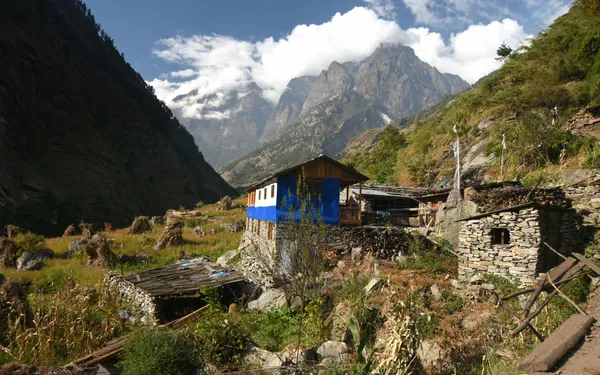 A traditional stone and timber house weathered against the mountain elements