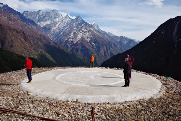 Trekkers taking in the mountain panorama from the high-altitude heliport