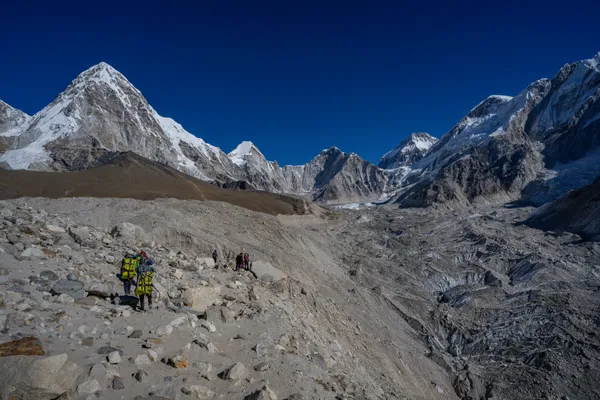 Hikers traversing the rocky glacial path at 4,940 meters toward Gorak Shep