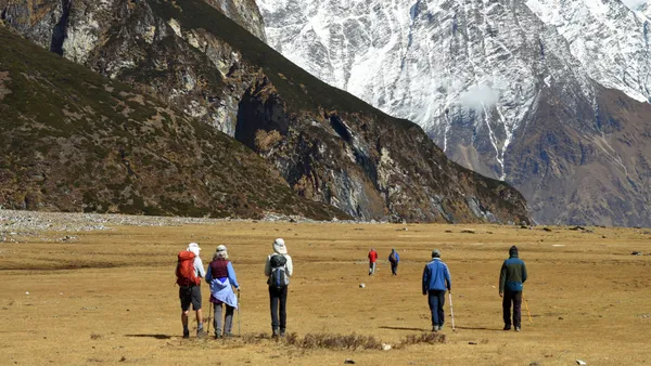 Trekkers crossing the flat open valley floor on the approach to Samdo