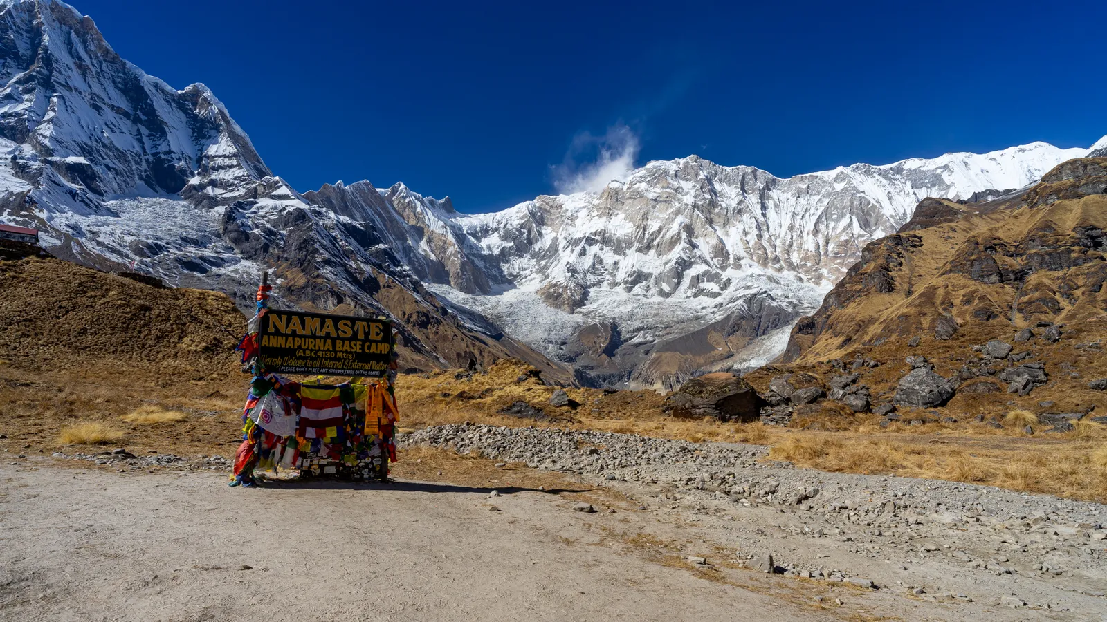 The Namaste sign at Annapurna Base Camp with the massive snow wall of Annapurna behind