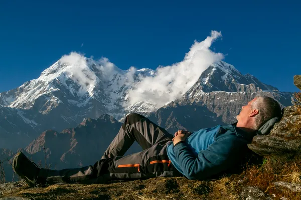 A trekker resting on the ridge with Annapurna South in the background
