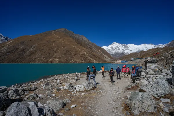 Hikers rest along the shores of Taujung Tsho