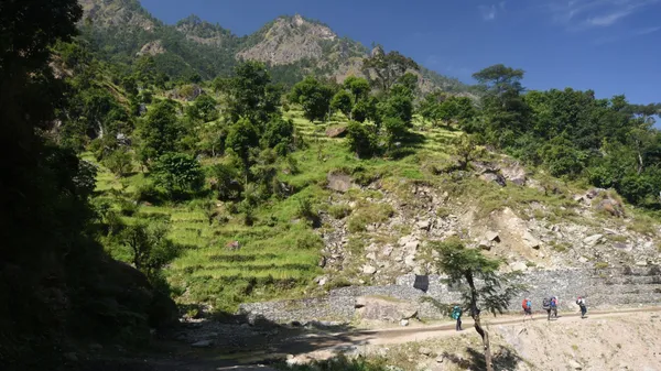 A trail hugging the riverbank on the approach to Machhakhola