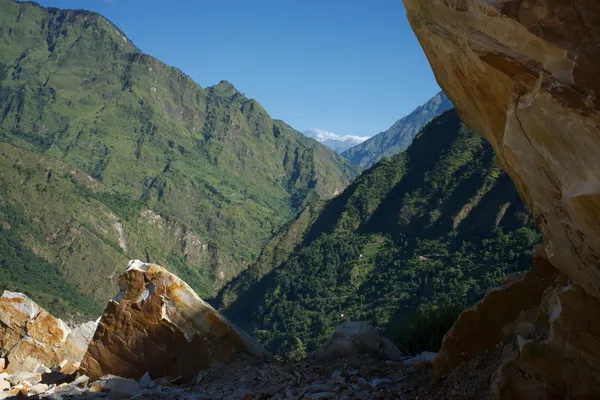 Massive rock faces with distant snow-capped peaks