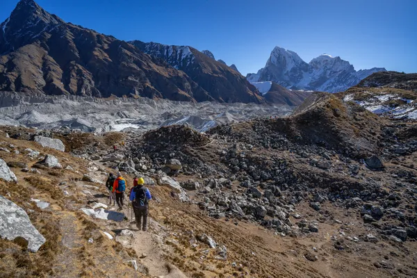 Hikers following the rocky trail from Thangnak toward the glacier moraine