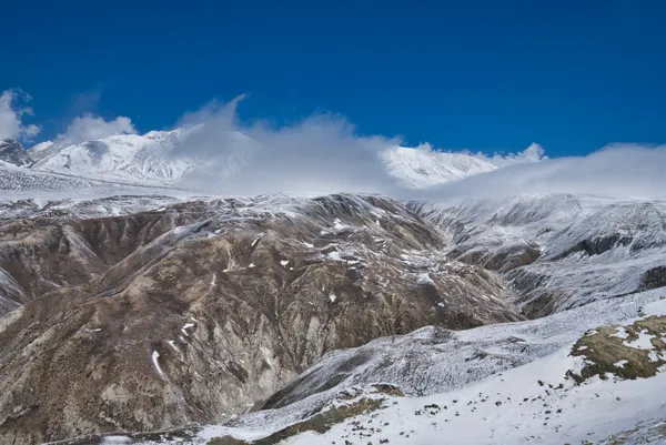 Dramatic clouds rolling over snow-covered Himalayan ridges near Lo Manthang