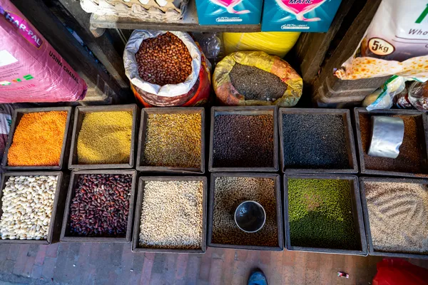 Neatly organized wooden crates of colorful lentils, beans, and seeds