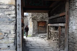 A villager walking through an ancient stone gateway