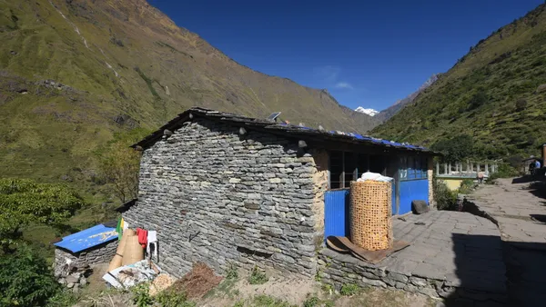 A traditional stone house in Philim with distant peaks