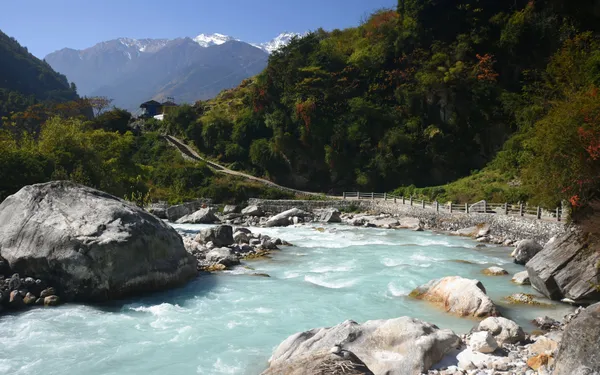 A well-built stone trail along the edge of a rushing mountain stream