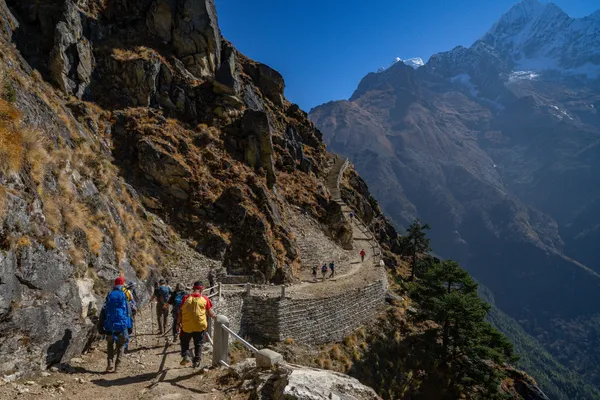 Trekkers navigate a steep stone staircase climbing toward the 3,970-meter pass