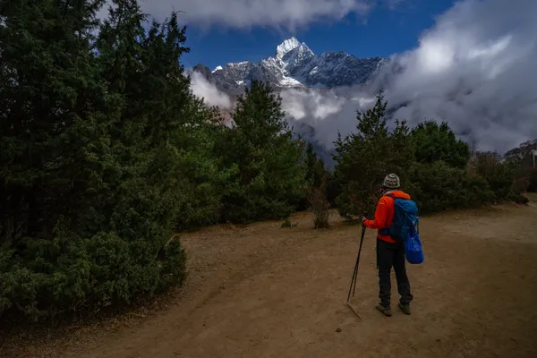 The trail winding upward from Namche toward the face of Thamserku