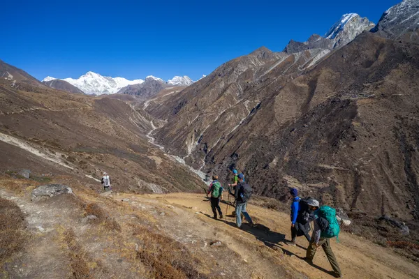 Hikers descend the trail from Dole toward Luza overlooking the deep river valley