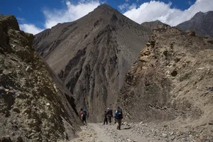 Trekkers dwarfed by barren peaks