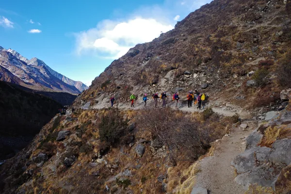 Trekkers walking the high trail toward Pangboche with peaks above 6,000 m