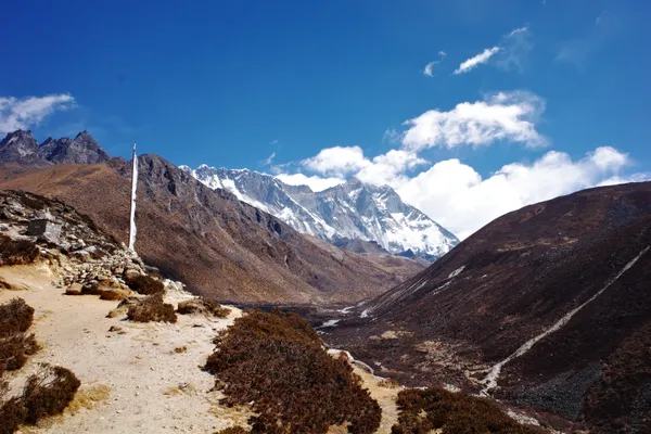 Trekkers following the trail from Pangboche toward the wall of Nuptse