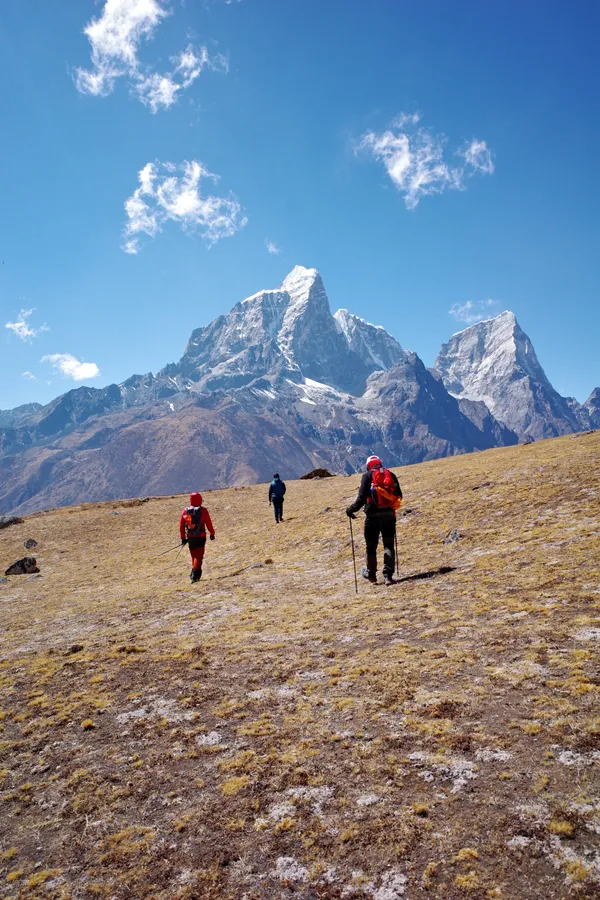 Trekkers ascending from Dingboche with Ama Dablam behind them