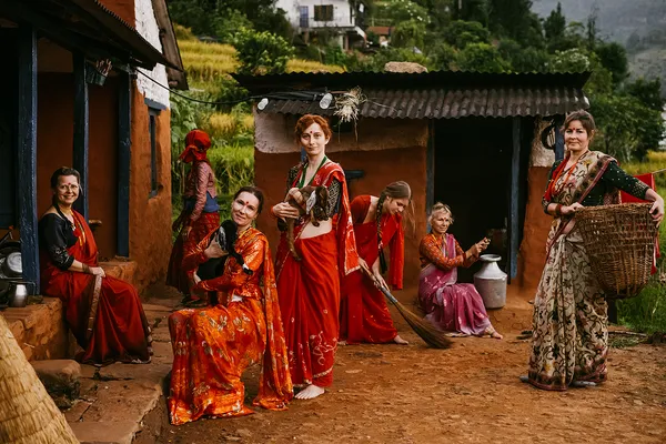 Visitors dressed in local attire joining daily chores at a traditional home
