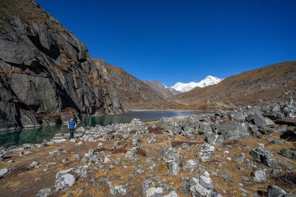 Trekkers pass the rocky shores of Taujung Tsho during the descent